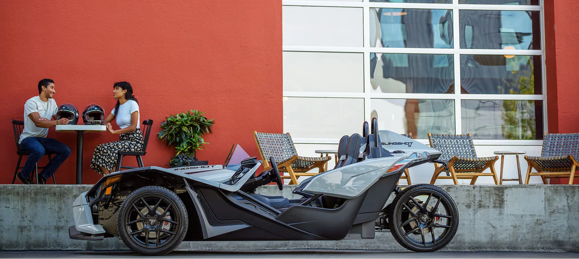 people getting lunch at a table near their polaris slingshot s