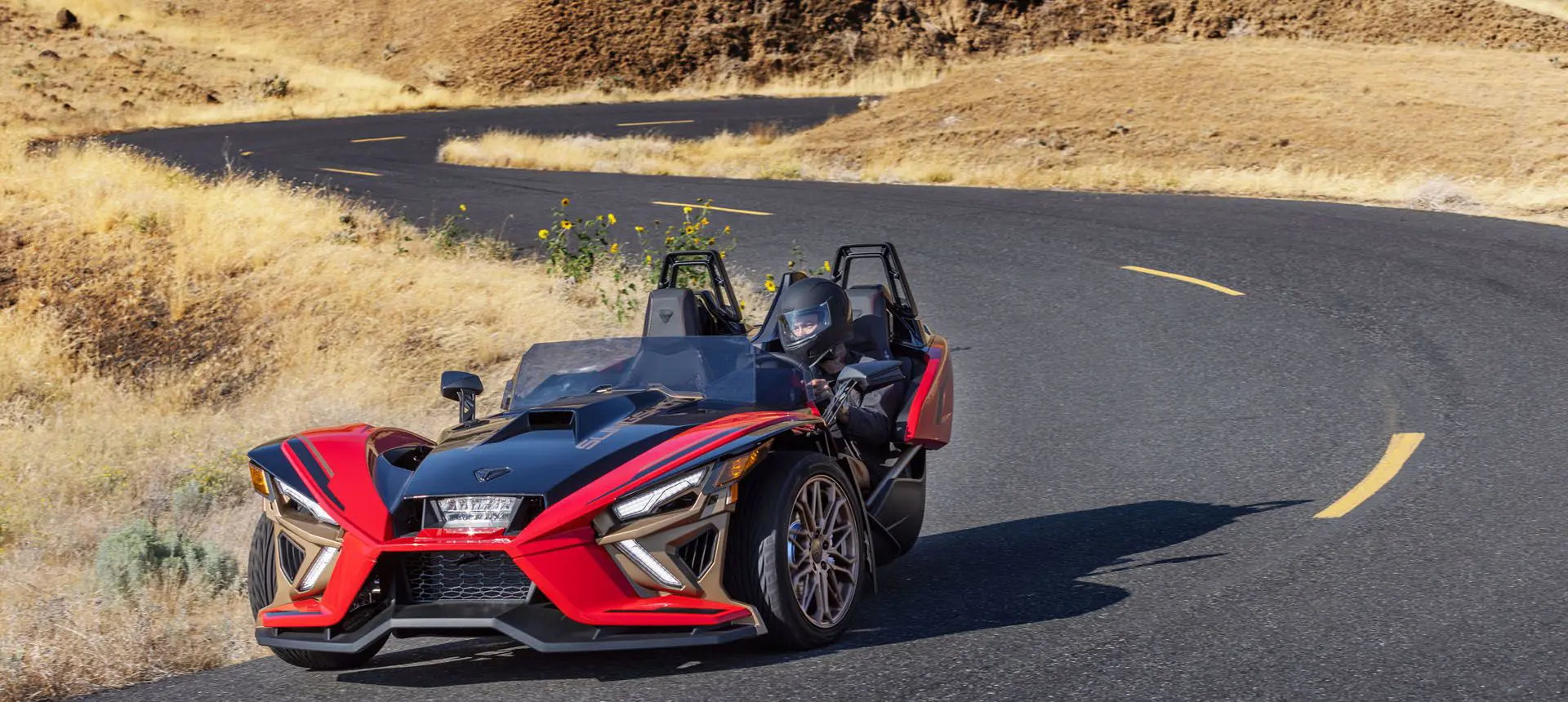Polaris Slingshot Signature LE conducido en un sendero curvo