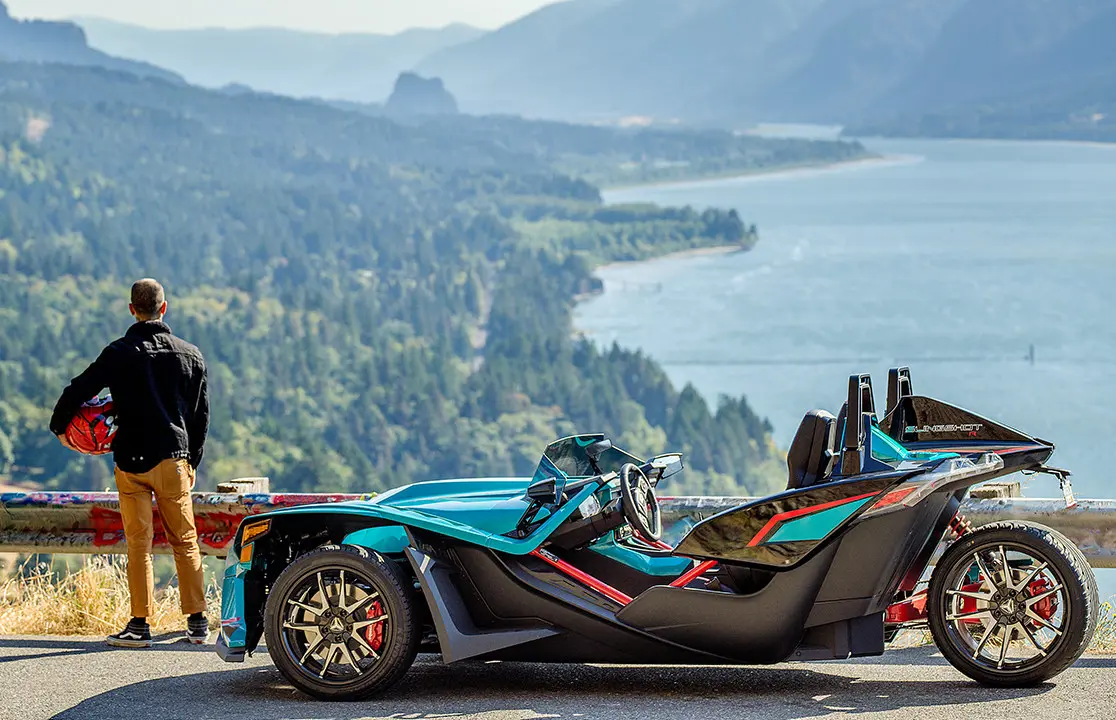 Man and woman getting on a Polaris Slingshot