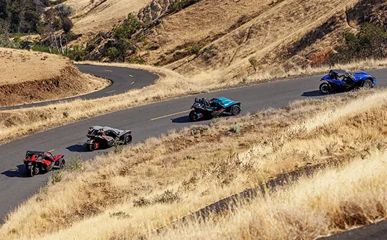 Four Polaris Slingshot vehicles on the road