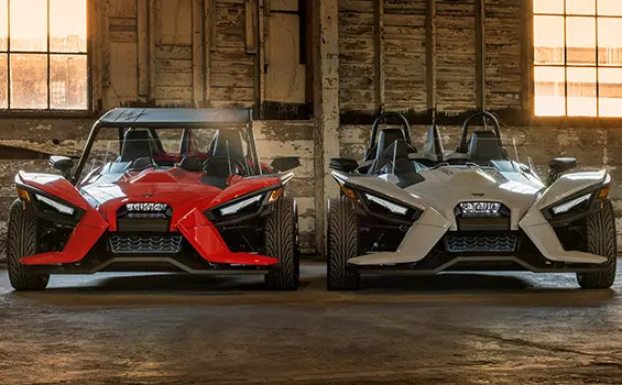 Two Polaris Slingshot vehicles parked on a warehouse
