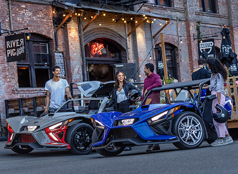 Cuatro amigos listos para subirse a sus vehículos Slingshot