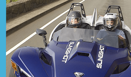 Two riders on Polaris Slingshot riding in a highway