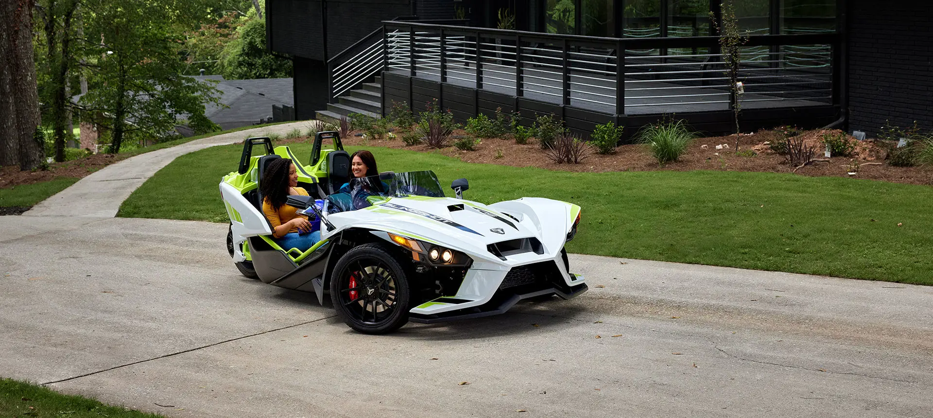 Deux femmes dans une moto à trois roues polaris slingshot r lime de rêve