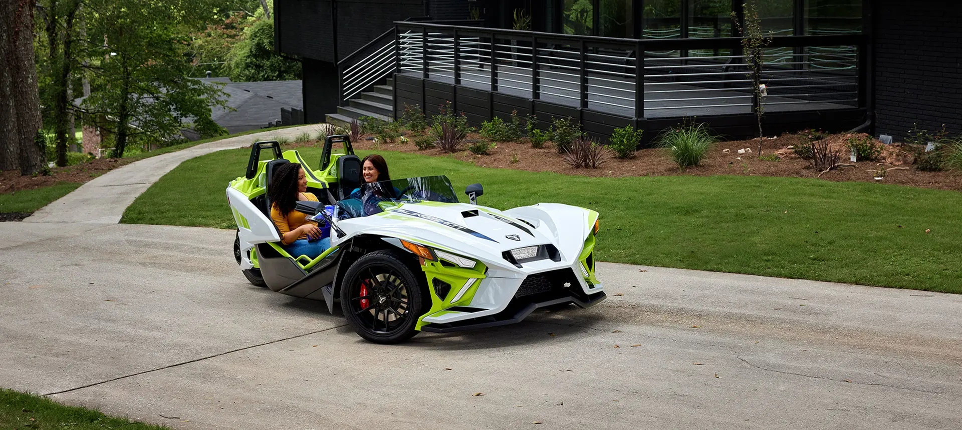 2 women in a lime dream polaris slingshot r three-wheeled motorcycle