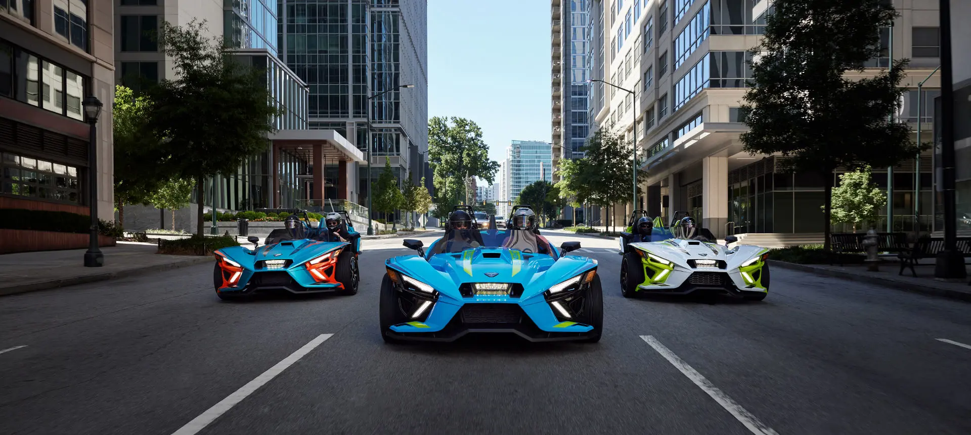 3 polaris slingshot r roadsters driving down a city street