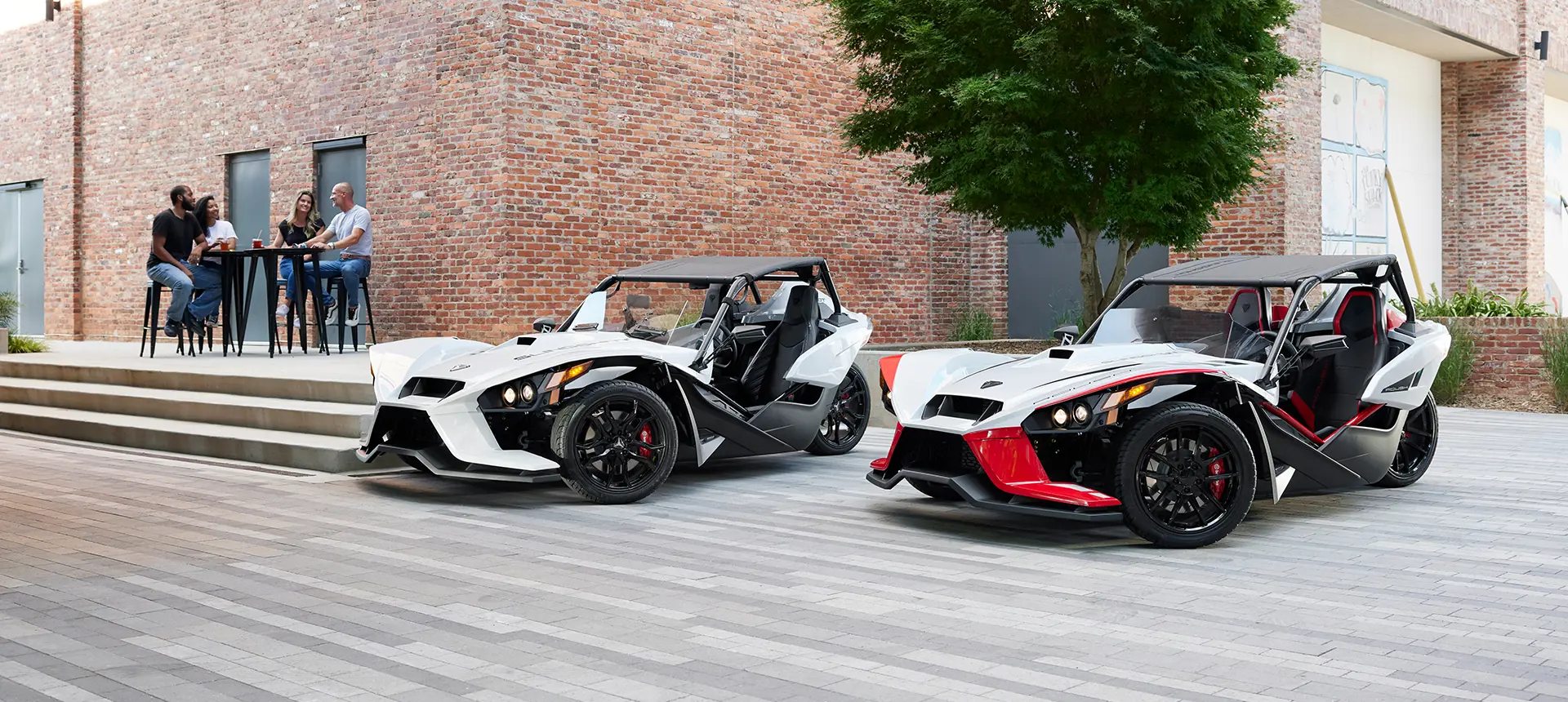 two people walking towards a 2024 polaris slingshot ROUSH® edition three-wheeled motorcycle