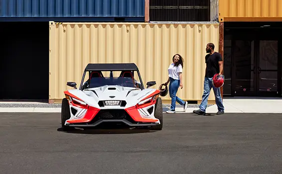 front view of a couple walkign towards a Slingshot ROUSH® Edition