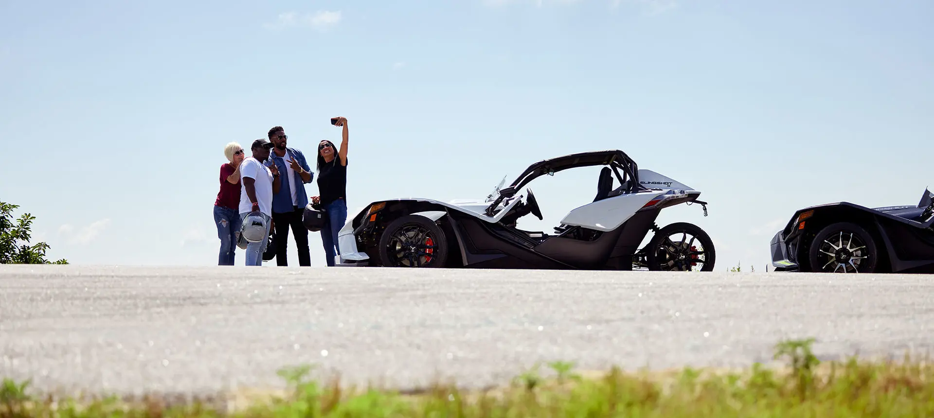 Friends taking a selfie near their polaris slingshot s roadsters