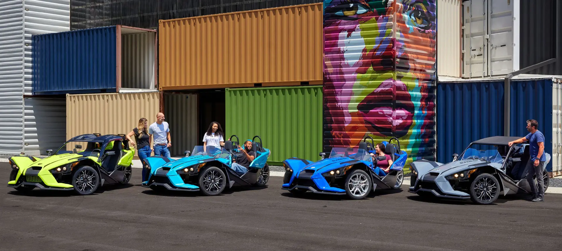 4 sets of people hanging around near their polaris slingshot sl three-wheeled roadsters