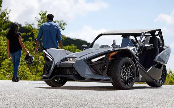 4 grupos de personas junto a sus roadsters de tres ruedas polaris slingshot sl