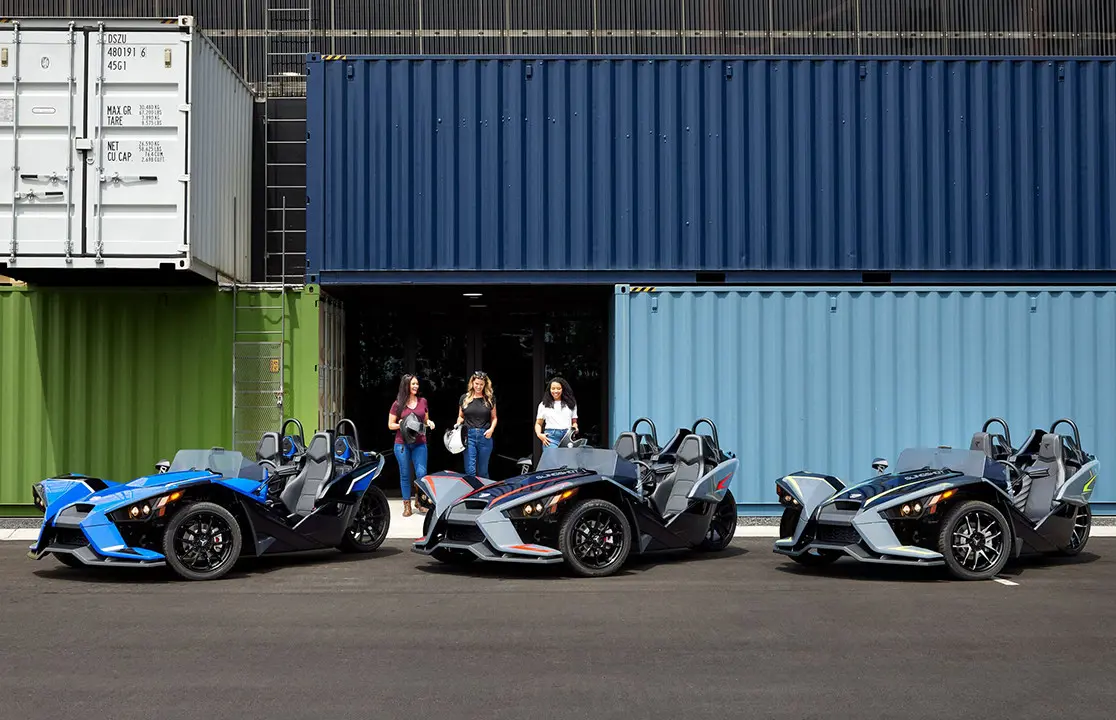 trois femmes debout près de leurs slingshots polaris slr roadsters