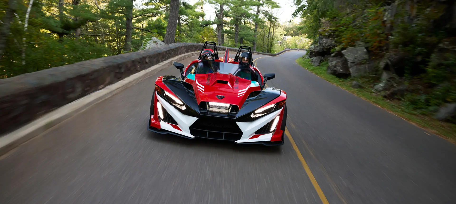 Front-end view of a 2025 Polaris Slingshot 10 3-wheel roadster cruising on a highway.