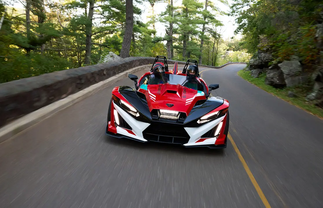 Front-end view of a 2025 Polaris Slingshot 10 3-wheel roadster cruising on a highway.