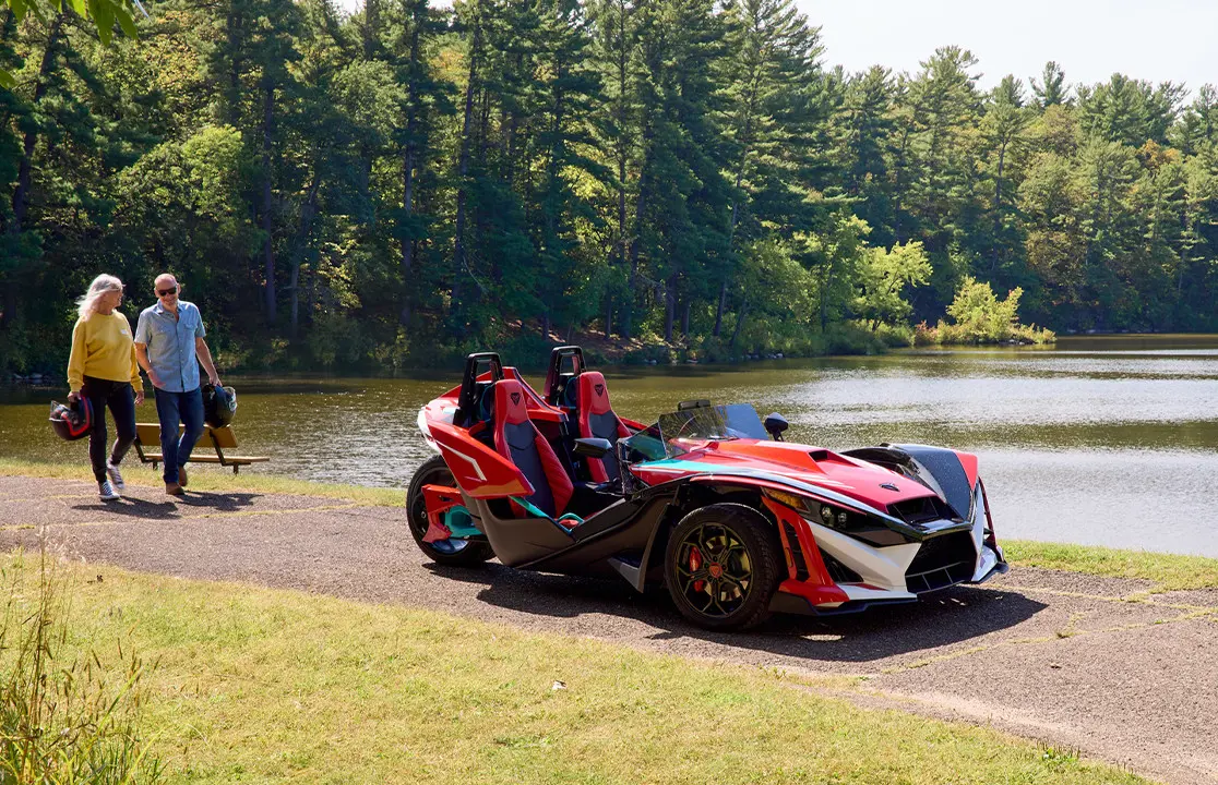 Vue frontale d’un cabriolet Polaris Slingshot R 2025 à trois roues roulant sur une route