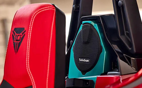 Une personne qui tient un téléphone cellulaire et utilise une application pour ajuster la couleur de l’éclairage de son cabriolet Polaris Slingshot 10 2025 à trois roues.