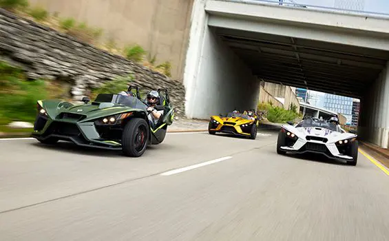 three 2024 slingshot r three-wheeled motorcycles cruising