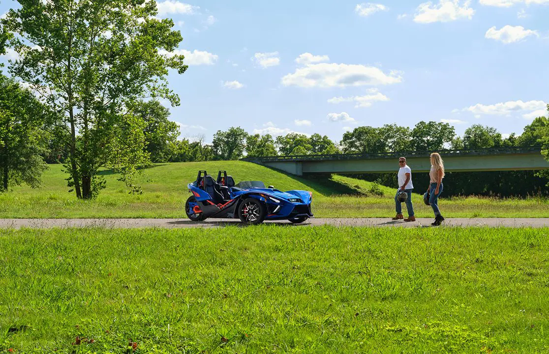 deux personnes marchant vers une moto à trois roues slingshot r 2024