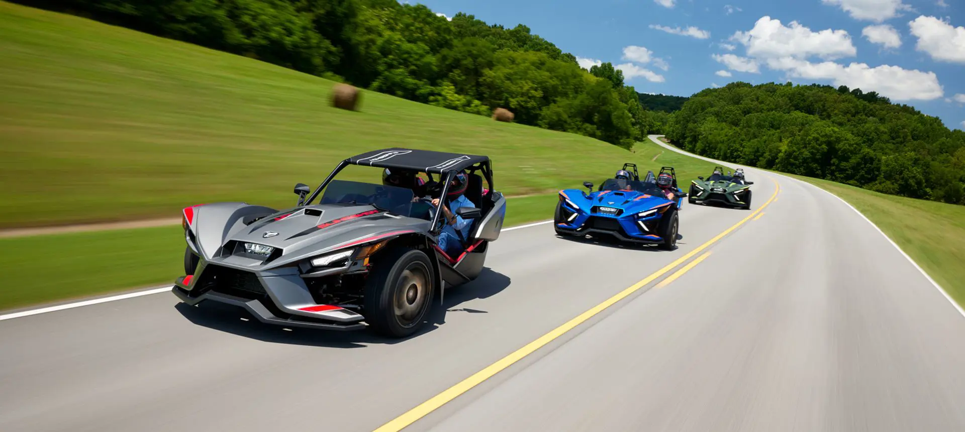 trois motos à trois roues Slingshot r 2024 circulant sur une route de campagne