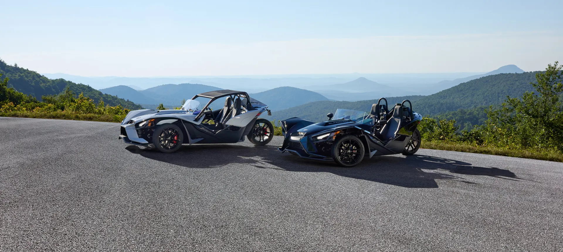 two 2024 slingshot s three-wheeled motorcycles parked on an overlook
