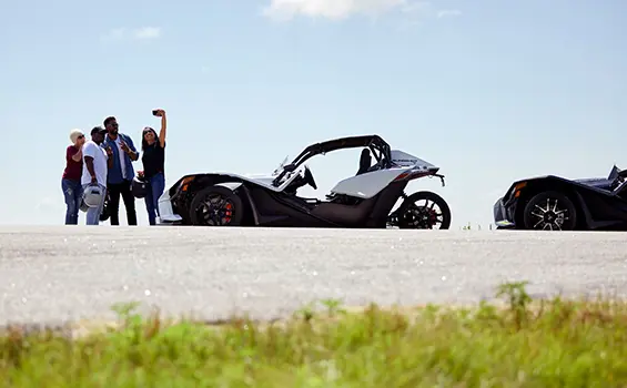 people taking a selfie after rides in their 2024 slingshot s three-wheeled motorcycles