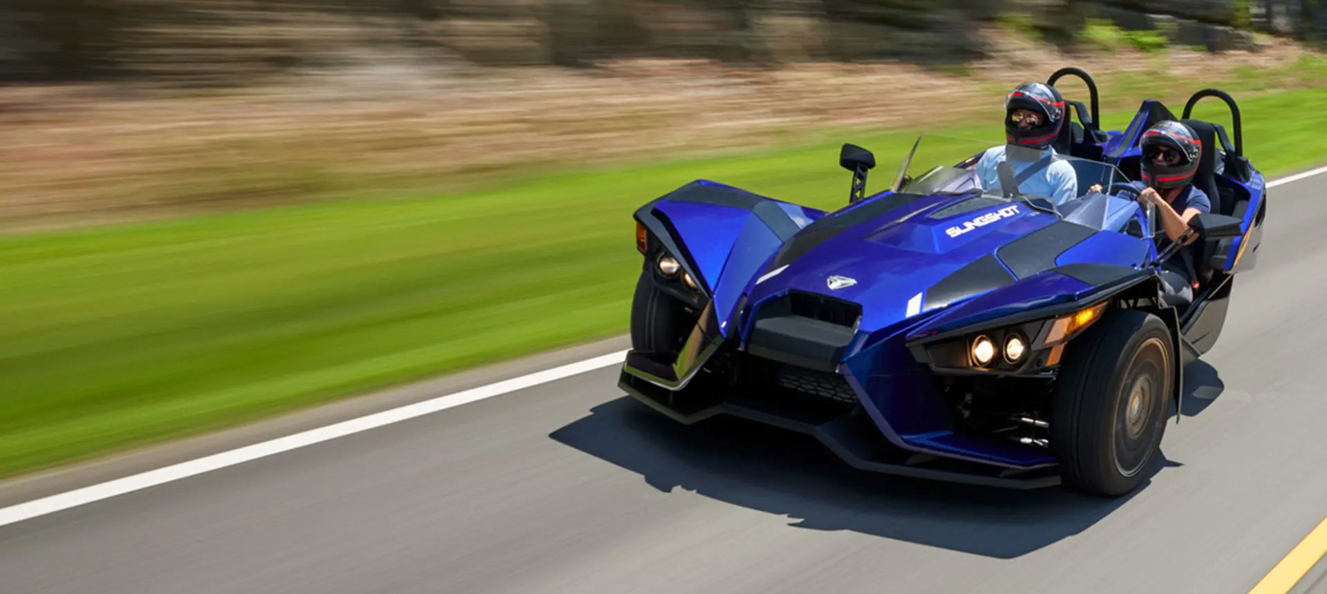 polaris slingshot SL three-wheeled motorcycle cruising on a highway