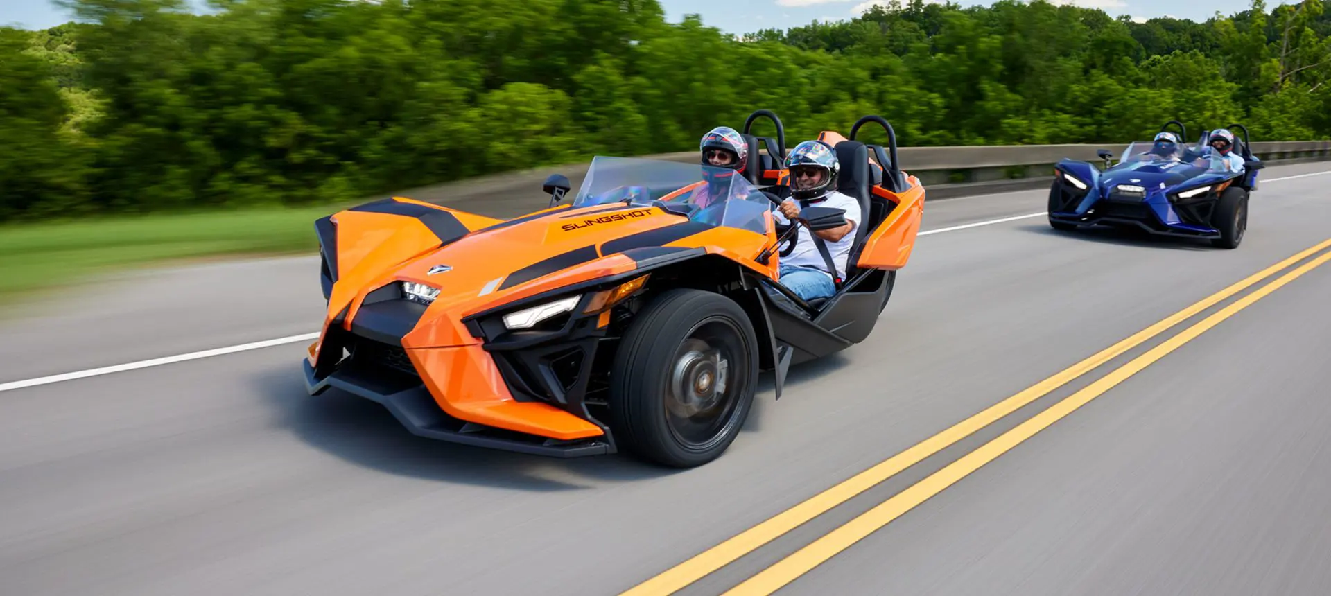 two polaris slingshot sl three-wheeled motorcycles on the highway