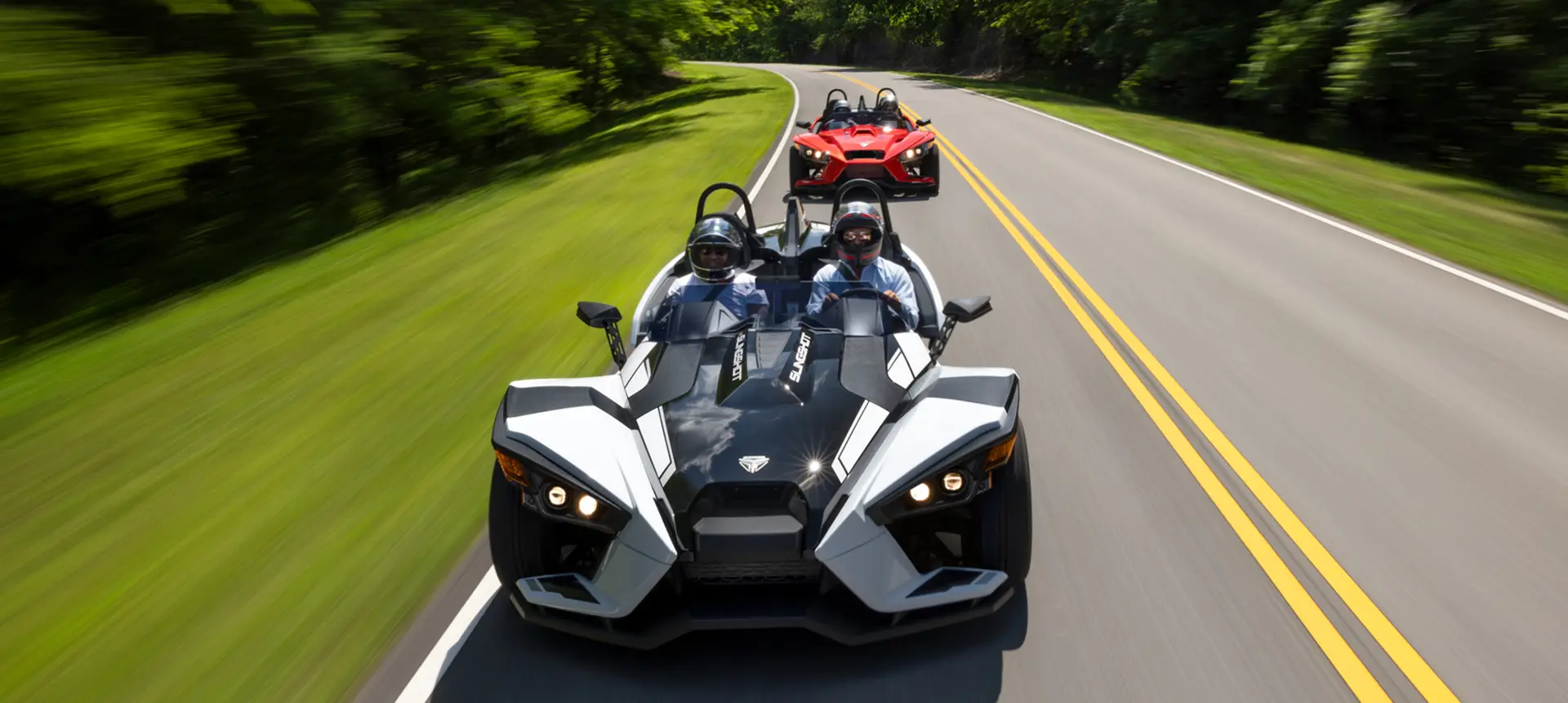 aerial view of 2 2024 polaris slingshot slr three-wheeled motorcycles on a highway