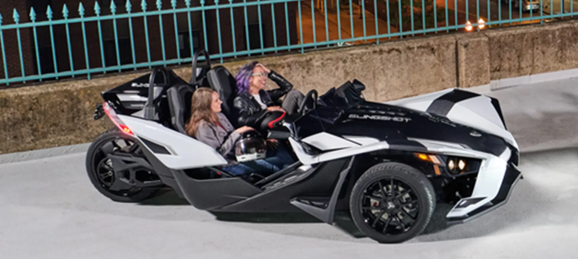 2 women laughing in a 2024 polaris slingshot slr three-wheeled motorcycle