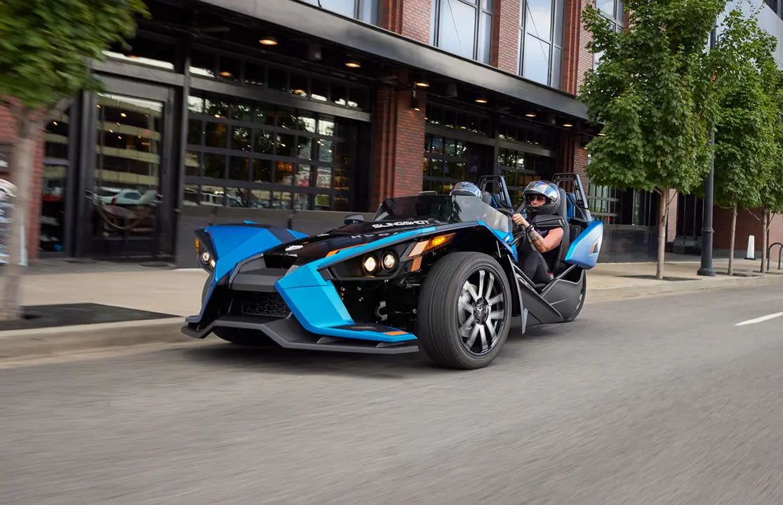 2024 polaris slingshot slr three-wheeled motorcycle cruising city streets
