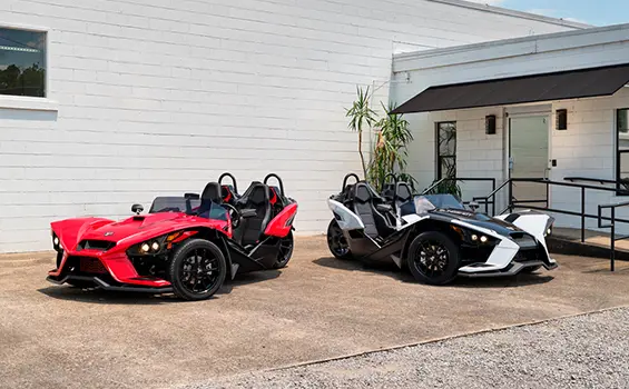 two 2024 polaris slingshot slr three-wheeled motorcycles parked