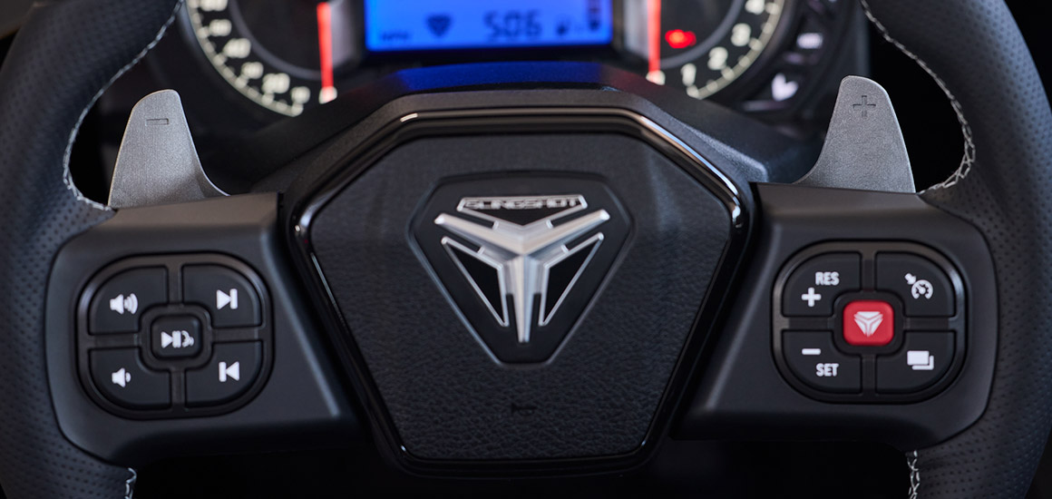A steering wheel with paddle shifters inside a Polaris Slingshot roadster.