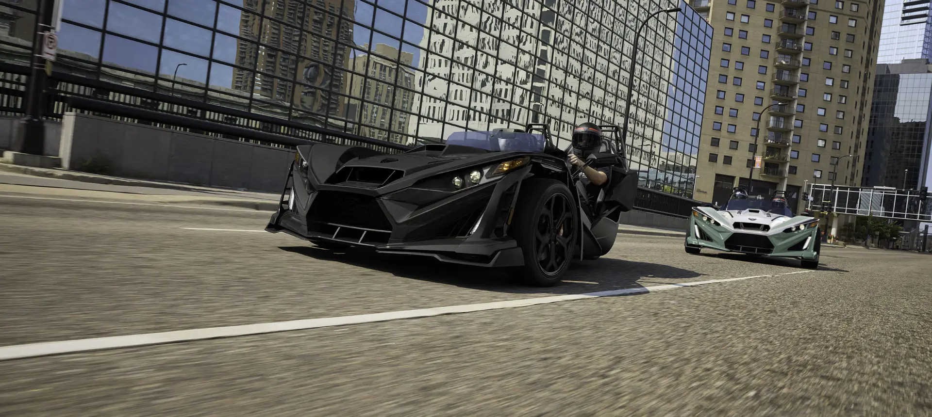 2 2026 Slingshot R three-wheel motorcycles cruising through a city.