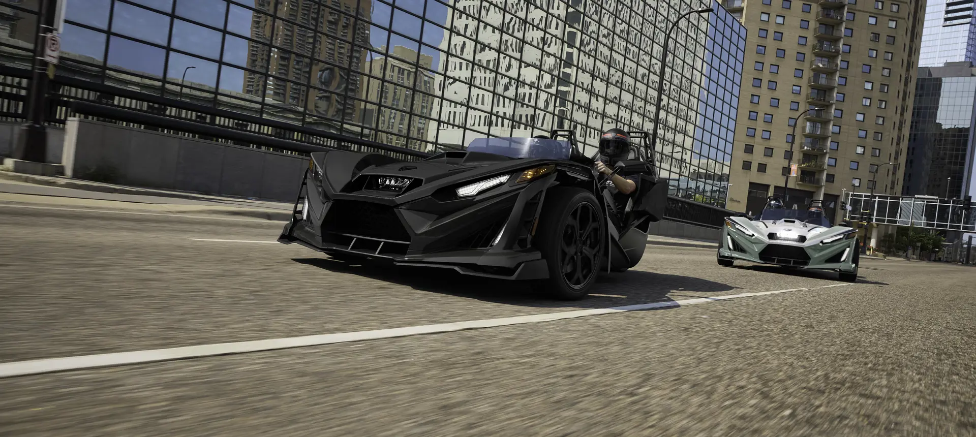 2 2026 Slingshot R three-wheel motorcycles cruising through a city.