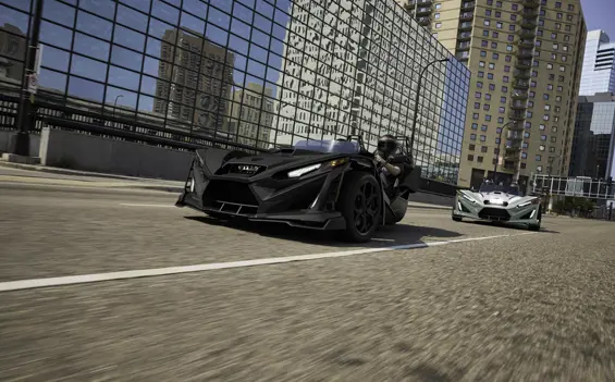 2 2026 Slingshot R three-wheel motorcycles cruising through a city.