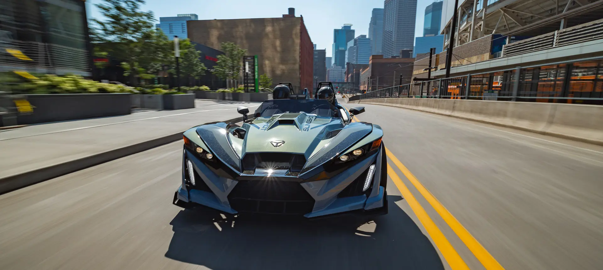 Front end view of a 2026 Polaris Slingshot Signature Edition 3-wheeled roadster cruising down a city street.
