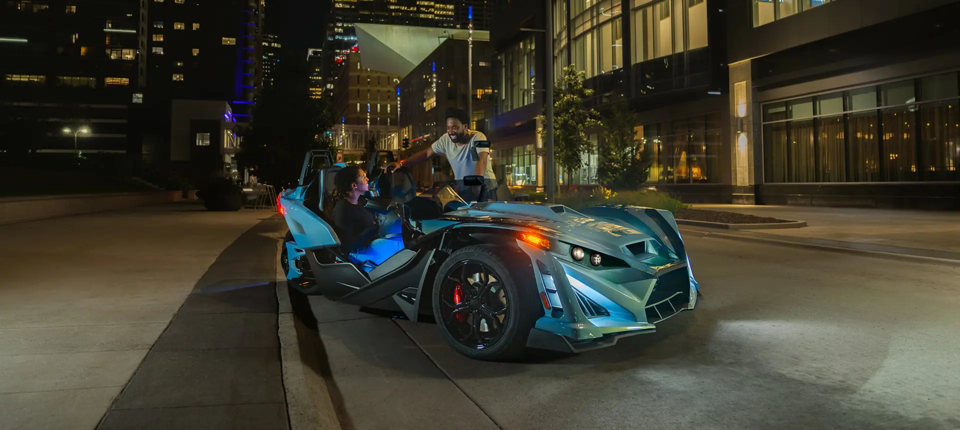 2026 Polaris Slingshot Signature Edition 3-wheeled roadster parked on a city street at night.