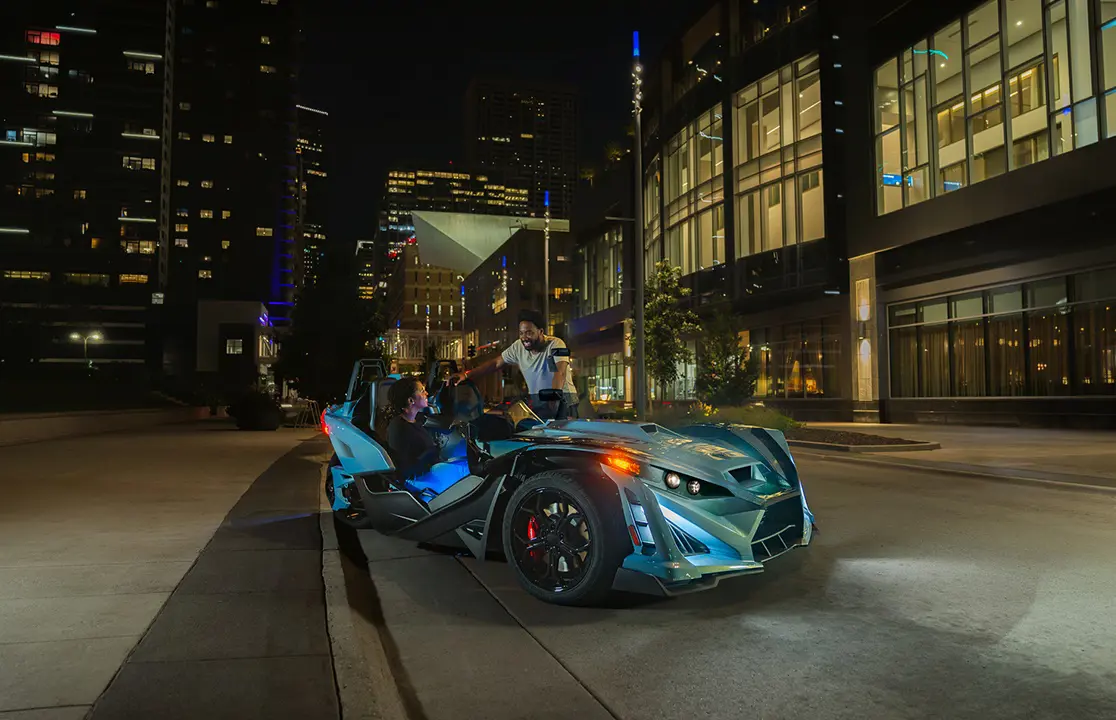 2026 Polaris Slingshot Signature Edition 3-wheeled roadster parked on a city street at night.