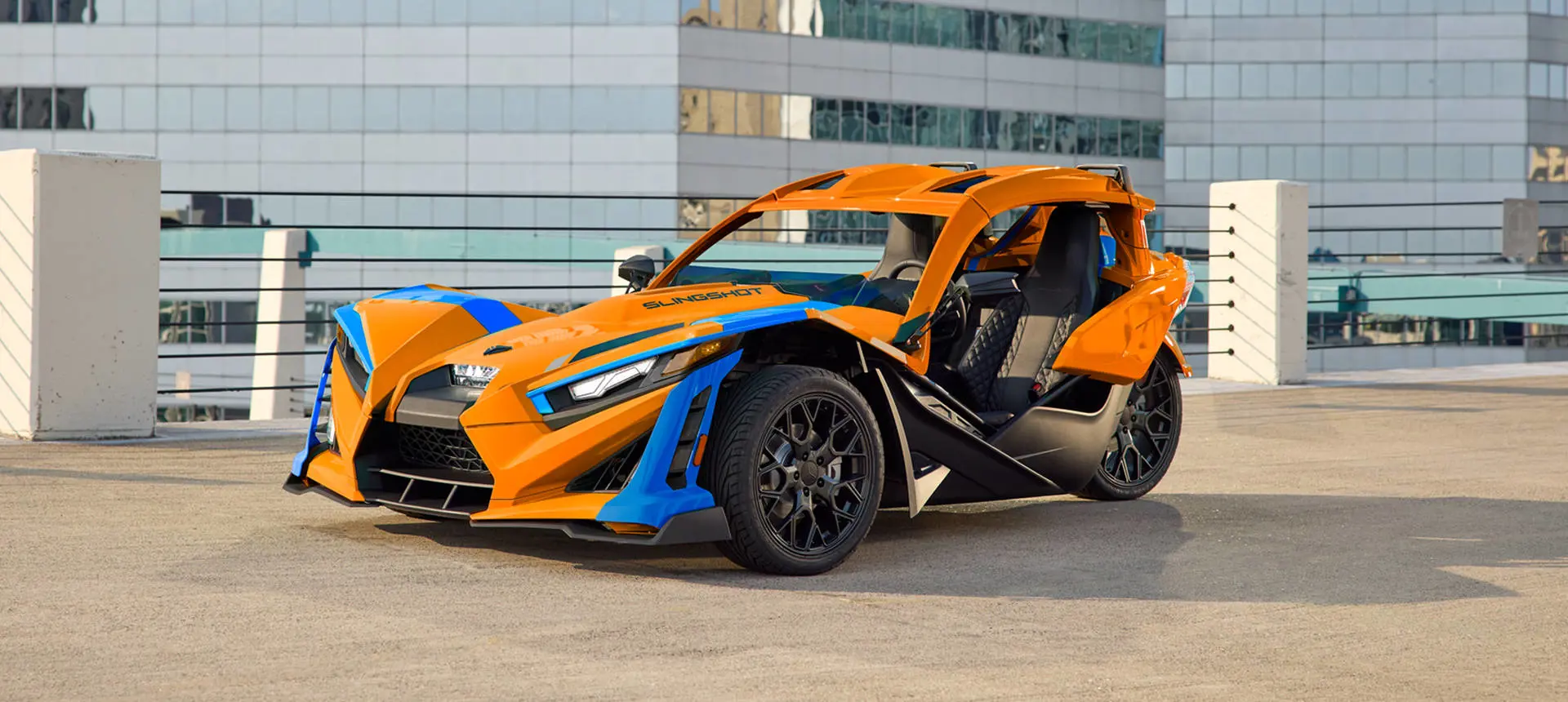 A 2026 Polaris Slingshot SL three-wheel motorcycle parked in a city.