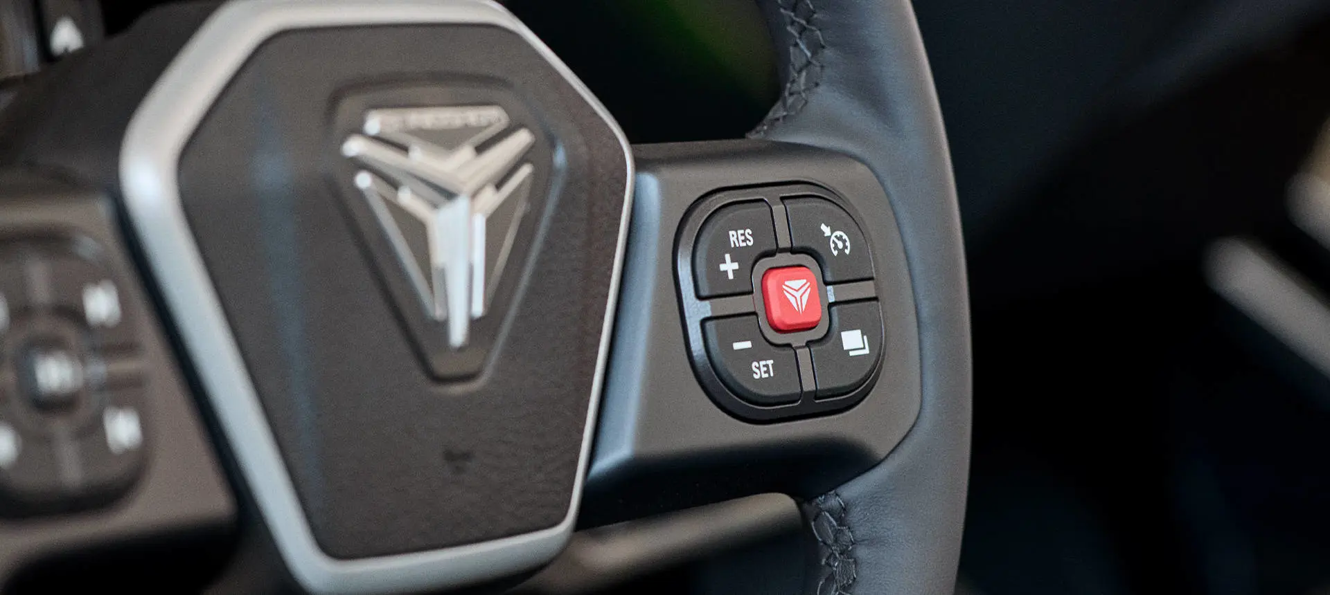 Closeup of the steering wheel and buttons in a 2026 Polaris Slingshot SL three-wheel roadster.