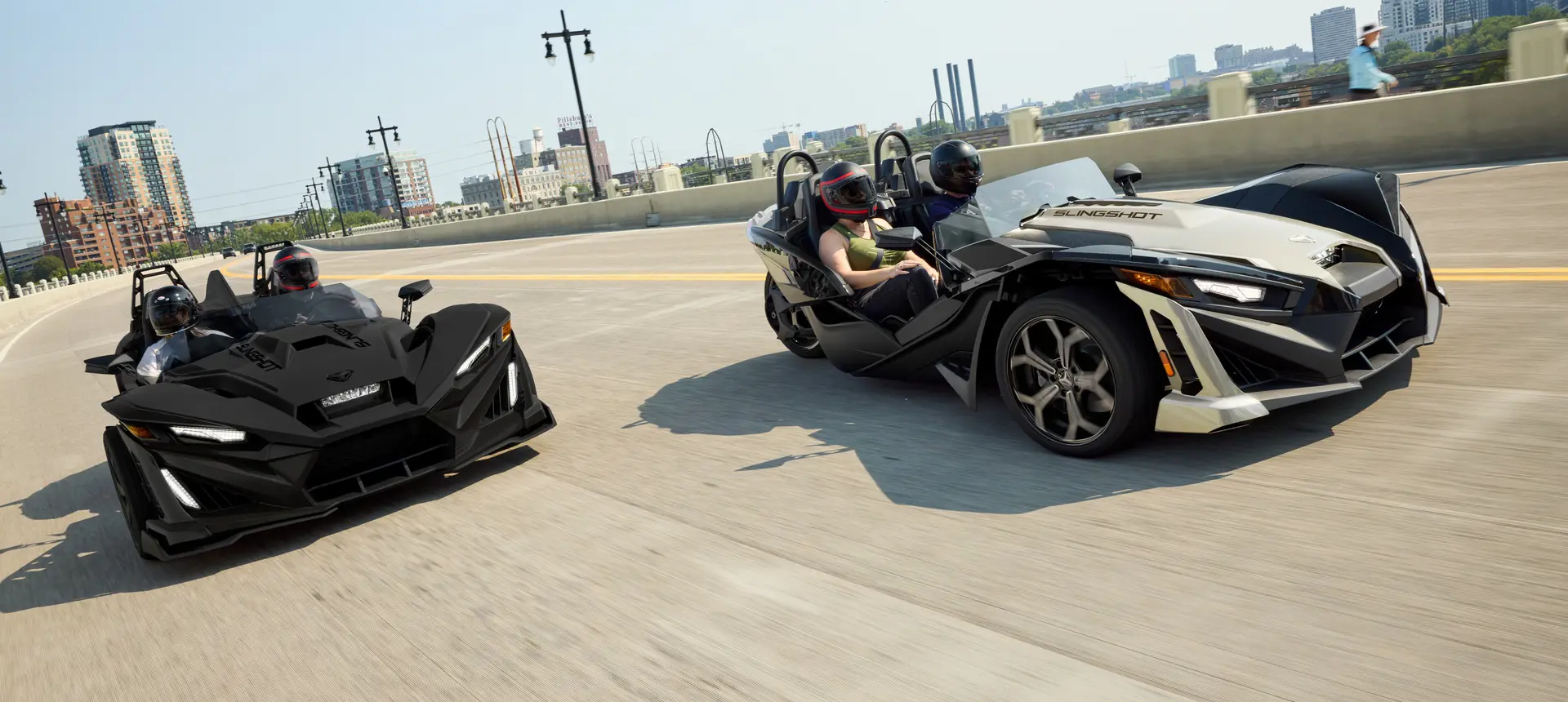 2 2026 Polaris Slingshot SLR three-wheel roadsters cruising down the road.