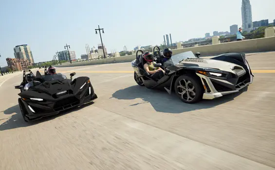2 2026 Polaris Slingshot SLR three-wheel roadsters cruising down the road.