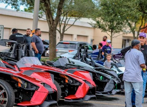 Slingshot 3 Wheel Vehicles displayed as attendees gather at an outdoor vehicle event.