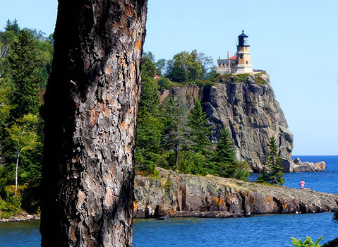 Split Rock Lighthouse overlooking the blue waters and rocky shoreline of Lake Superior.