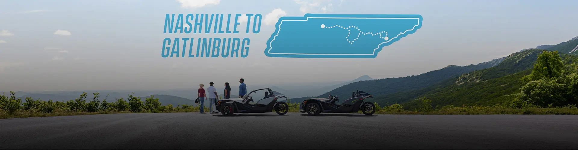 Two Polaris Slingshot roadsters parked at a mountain overlook on a Nashville-to-Gatlinburg route.