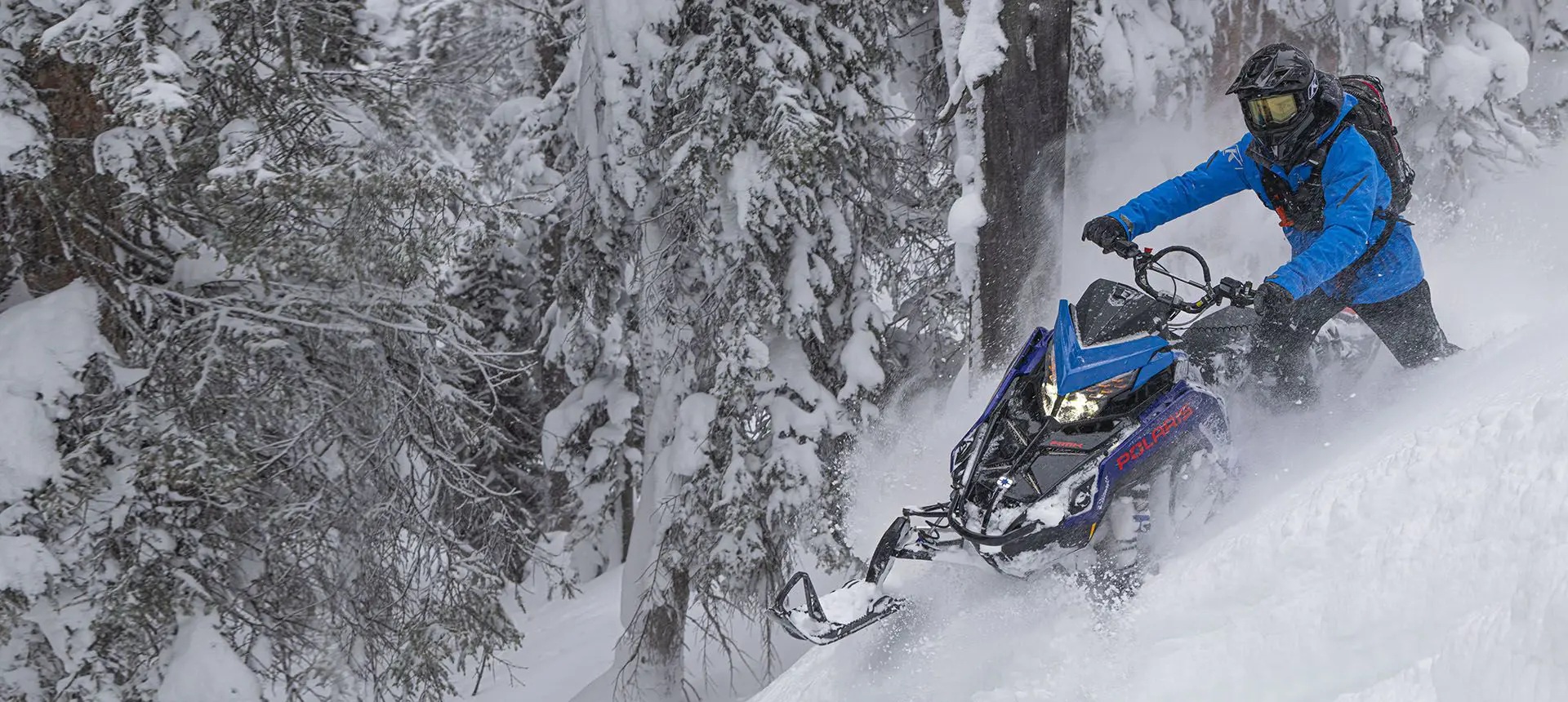 rider cutting through deep snow on his polaris pro rmk slash snowmobile