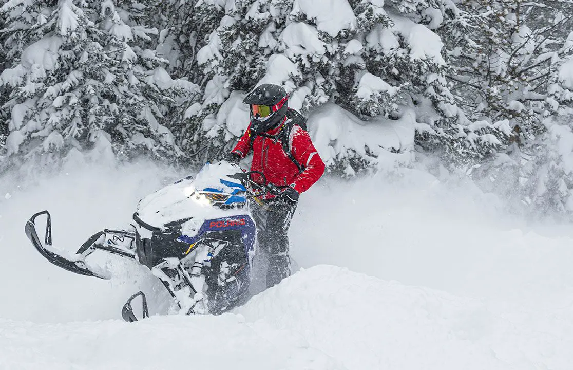 rider powering through deep snow on a polaris pro rmk slash snowmobile