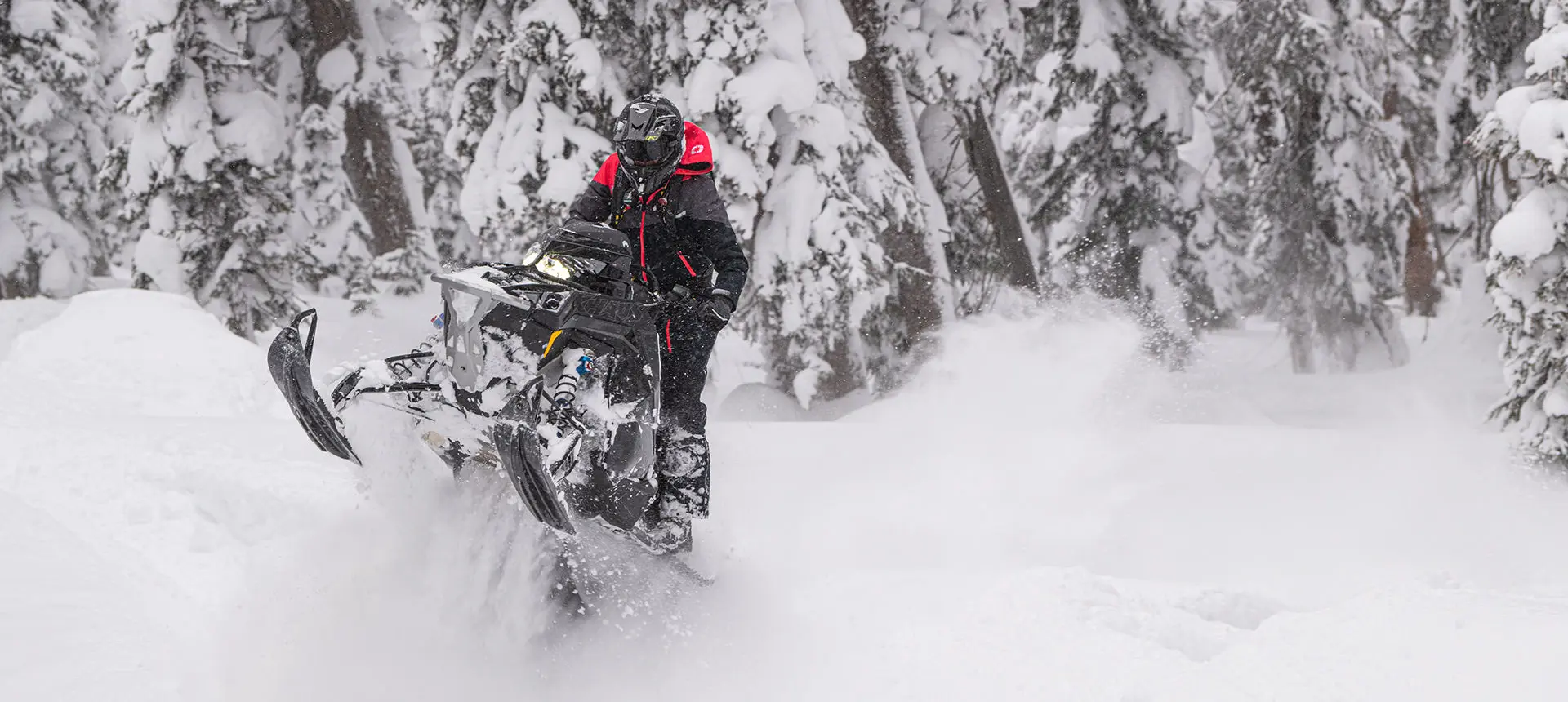 rider doing a wheelie on a polaris rmk khaos slash snowmobile