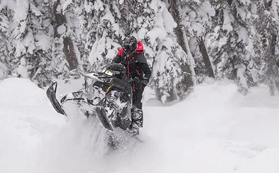 rider doing a wheelie on a polaris rmk khaos slash snowmobile