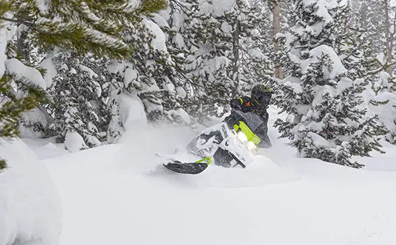 rider taking a swift turn on a polaris sks 146 snowmobile